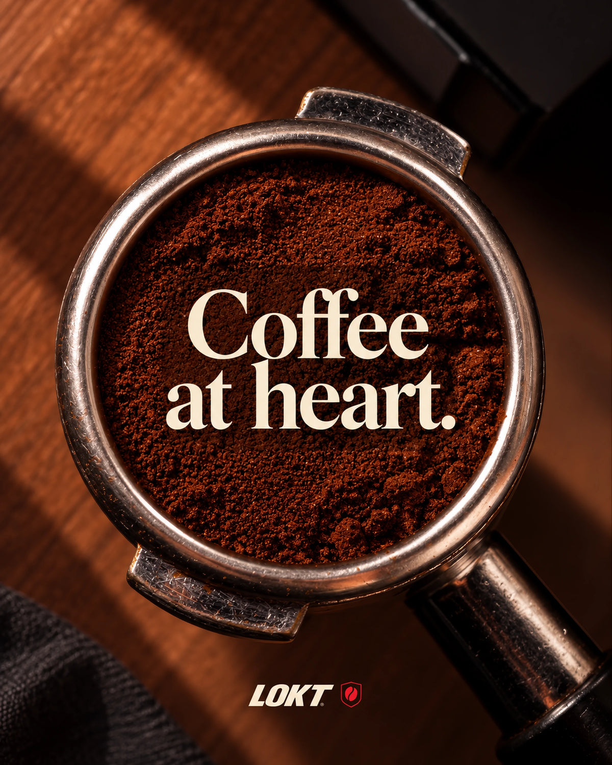 Ground coffee in a portafilter with the words Coffee at heart