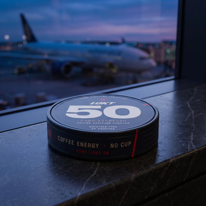 A LOKT 50 Dark Espresso can on an airport windowsill at blue hour