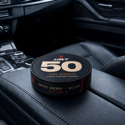 A LOKT 50 Dark Espresso tin resting on the centre console of a car