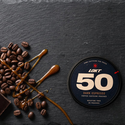 Closed LOKT 50 Dark Espresso can on dark slate with roasted beans, dark chocolate shards and a caramel drizzle, the flavor notes laid out around the tin