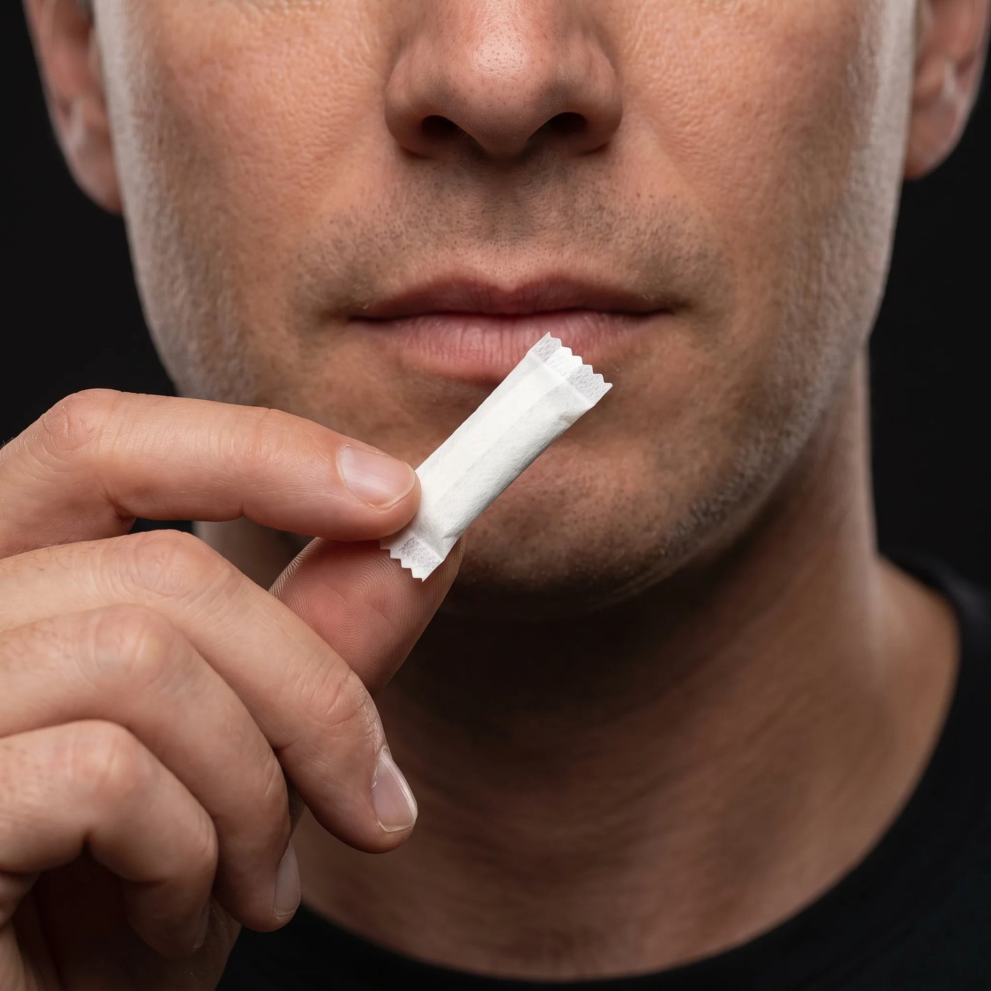 A LOKT 50 coffee caffeine pouch being placed under the upper lip
