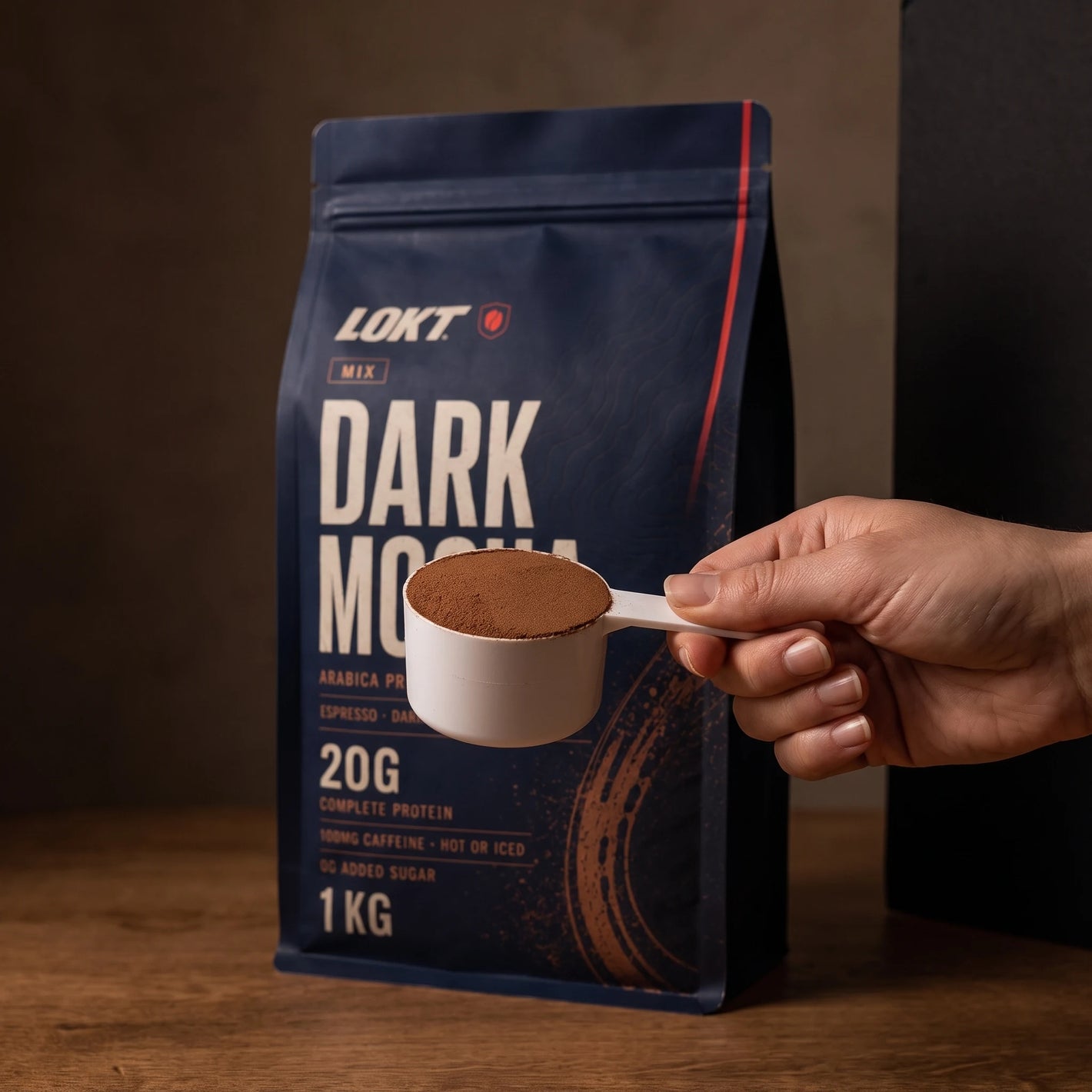 One level 36g scoop of LOKT MIX Dark Mocha held in hand for scale