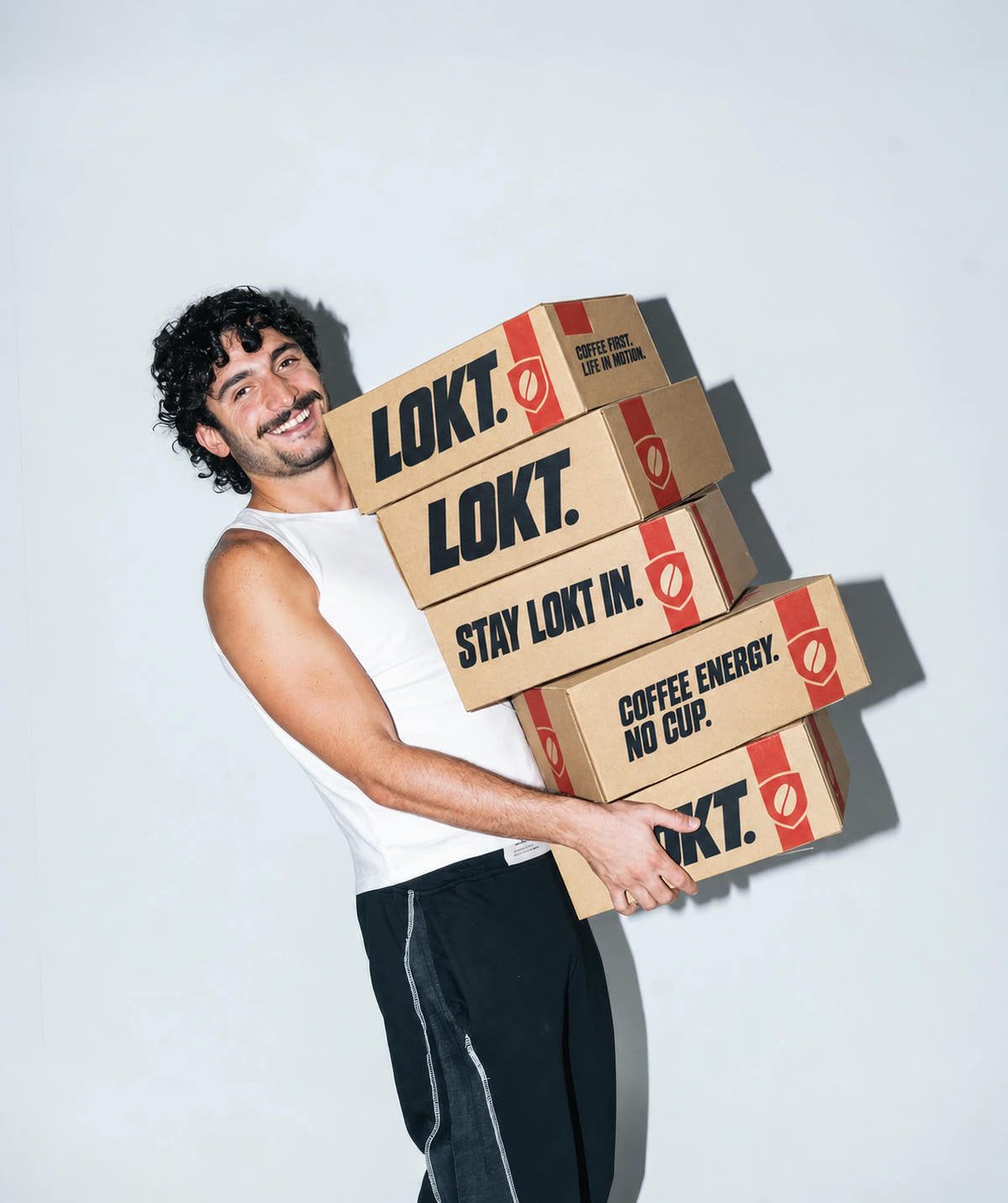 A man carrying LOKT coffee boxes printed with Stay LOKT In