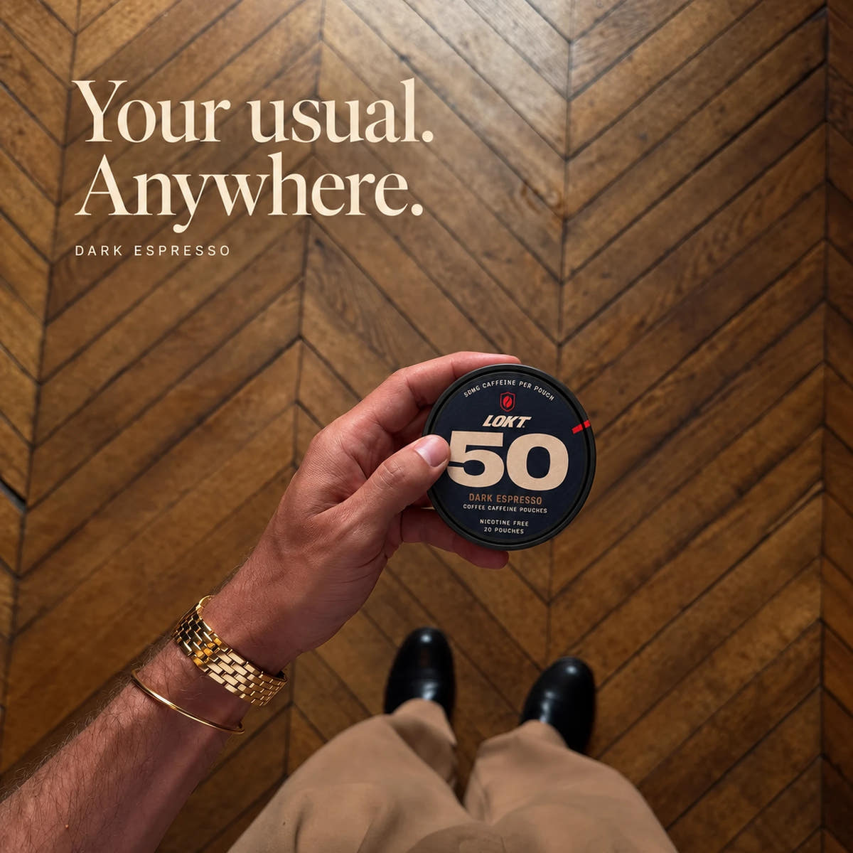 Your usual. Anywhere. A closed Dark Espresso tin in hand over a herringbone floor, with tan trousers and polished shoes.