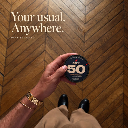 Your usual. Anywhere. A closed Dark Espresso tin in hand over a herringbone floor, with tan trousers and polished shoes.